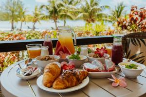 een tafel met ontbijtproducten en drankjes op een balkon bij Tai Roto Bay in Arutanga