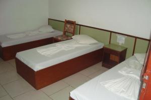 a room with two beds and a chair in it at Unihotel in Hortolândia