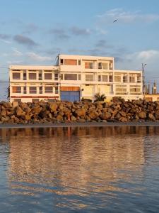 a building on the shore of a body of water at Hotel Ola Bella in San Clemente