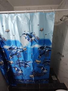 a shower curtain with dolphins in the water at Quinta Pehuen in Tortuguitas +13 photos