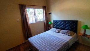 a bedroom with a bed with a blue headboard and a window at Quinta Pehuen in Tortuguitas