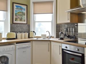 a kitchen with a sink and a dishwasher at Cliff Railway Apartment in Aberystwyth