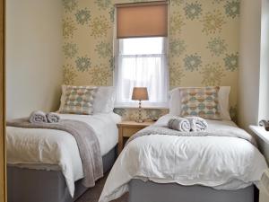 a bedroom with two beds and a window at Cliff Railway Apartment in Aberystwyth