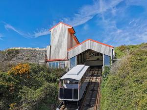 a train on the tracks in front of a building at Cliff Railway Apartment in Aberystwyth