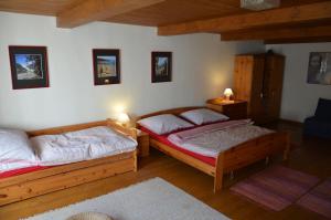 een slaapkamer met 2 bedden en een blauwe stoel bij Růžová chalupa u Šimánků in Rtyně v Podkrkonoší
