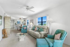 uma sala de estar com um sofá, cadeiras e uma mesa em Estero Cove 341 em Fort Myers Beach