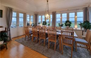 uma sala de jantar com uma mesa longa e cadeiras em 5 Bedroom Pet Friendly Home In Sollebrunn em Sollebrunn