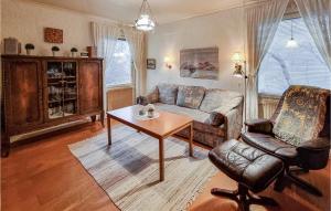 a living room with a couch and a table and a chair at Stunning Home In Bullaren With 1 Bedrooms in Bullaren