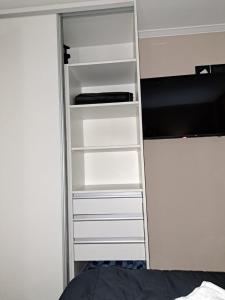 a closet with white shelves next to a bed at La Marta in Ciudad Lujan de Cuyo