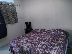 a bedroom with a bed with a quilt on it at Casa Jeymar in Coyuca