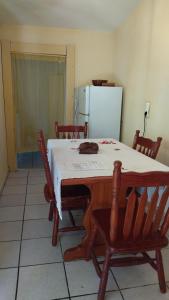 eine Küche mit einem Tisch mit Stühlen und einem Kühlschrank in der Unterkunft La Creoline 01 in Pointe-Noire