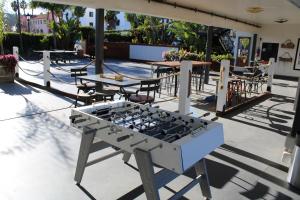 a barbecue grill on a patio with tables and chairs at Haley Hotel in Santa Barbara
