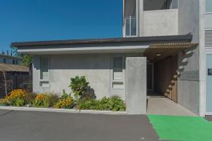 a facade of a building with a garage at Malthouse Lane City Apartment 3 in Nelson