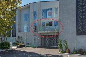 een rode cirkel aan de zijkant van een gebouw bij Malthouse Lane City Apartment 3 in Nelson
