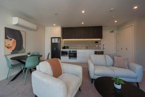 a living room with a couch and chairs and a kitchen at Malthouse Lane City Apartment 3 in Nelson +22 photos