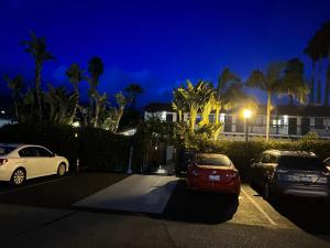 dos autos estacionados en un estacionamiento por la noche en Haley Hotel en Santa Bárbara