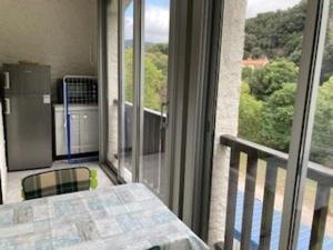 Cette chambre dispose d'un balcon avec une table et une fenêtre. dans l'établissement Appartement F2 Confortable à Amélie-les-Bains – Balcon, Parking, Proche Thermes, Animaux Bienvenus - FR-1-703-15, à Amélie-les-Bains-Palalda