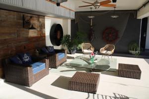 un patio con sillas de mimbre y una mesa de cristal en Haley Hotel en Santa Bárbara