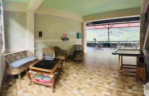 sala de estar con mesa de ping pong y sillas en The Mandarine Retreat en Mangan