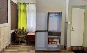 einen Kühlschrank in einem Zimmer mit einem Tisch und einem Stuhl in der Unterkunft The Mandarine Retreat in Mangan