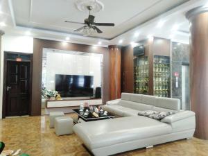 a living room with a white couch and a tv at Khách sạn Crown - Gần đại học Nông Lâm TN in Thái Nguyên