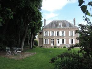 uma grande casa de tijolos com uma mesa no quintal em Chambres d'Hôtes de la Bucaille em La Bucaille