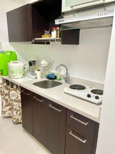 a kitchen counter with a sink and a stove at Pico De Loro Hamilo Coast beach and Country Club - Myna B One Bedroom in Cutad