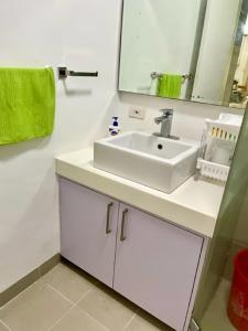 a bathroom with a white sink and a mirror at Pico De Loro Hamilo Coast beach and Country Club - Myna B One Bedroom in Cutad