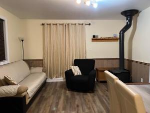 a living room with a couch and a wood stove at Le Chal'heureux, ski & spa, ski-in ski-out in Val-Brillant