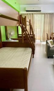 two bunk beds in a room with a couch at Pico De Loro Hamilo Coast beach and Country Club - Myna B One Bedroom in Cutad