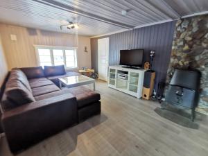 a living room with a couch and a fireplace at Tangen - cabin with 4 bedrooms - great nature in Norheimsund