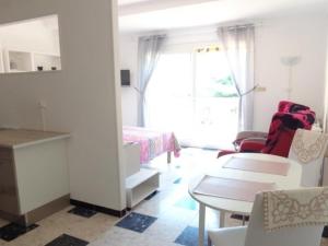 sypialnia z łóżkiem, stołem i krzesłami w obiekcie Charmant F1 avec terrasse et garage, proche cures et centre-ville d'Amélie-les-Bains. - FR-1-703-73 w mieście Amélie-les-Bains-Palalda