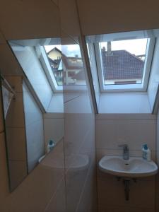 ein Badezimmer mit einem Waschbecken und zwei Oberlichtern in der Unterkunft Hotel Engel in Waldbronn