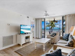 uma sala de estar com uma televisão de ecrã plano e um sofá em Estero Island Beach Villas 204, Sleeps 8, 2 Bedrooms, Gulf Front, Heated Pool em Fort Myers Beach