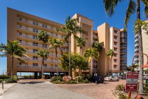 um grande edifício com palmeiras num parque de estacionamento em Estero Island Beach Villas 204, Sleeps 8, 2 Bedrooms, Gulf Front, Heated Pool em Fort Myers Beach