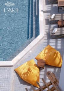 ENNKAI Beachfront Resort Koh Larn في باتايا سنترال: مسبح به بطانتين صفراء بجانب مسبح