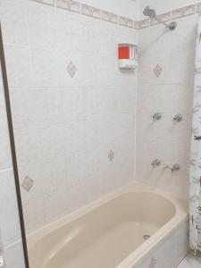 biała łazienka z wanną i prysznicem w obiekcie Turtle Cottage Magnetic Island w mieście Picnic Bay