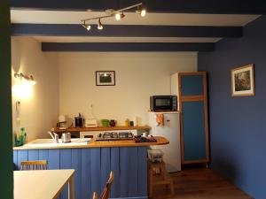 una cucina con pareti blu e frigorifero bianco di Chez Nany, chaleureux duplex sur le port de Morgat a Crozon