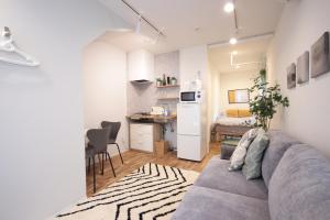 uma sala de estar com um sofá e uma pequena cozinha em LaLaCUBE Kitasenju em Tóquio