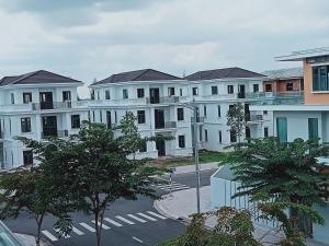 a group of white buildings with trees in front of them at MOTEL MINH ANH in Ấp Rạch Mẹo