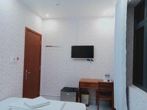 a bedroom with a desk and a tv on the wall at MOTEL MINH ANH in Ấp Rạch Mẹo