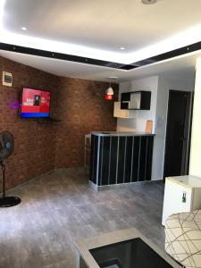 een woonkamer met een tv aan een bakstenen muur bij Logan Apartments in Bantayan