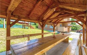 a large wooden pavilion with a bench in a yard at Nice Apartment In Ogulin With Kitchen in Jasenak