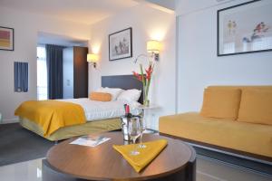 a hotel room with a bed and a coffee table at Apartahotel Altos de la Sabana in San José