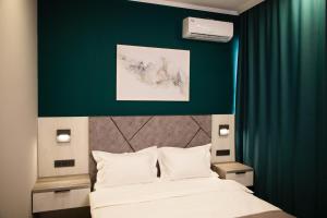 a bedroom with a bed and a green wall at Zodiac in Atyrau