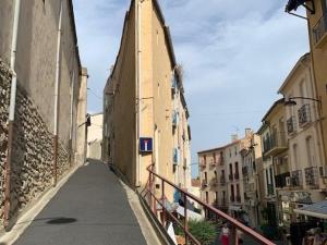 wąska uliczka z budynkiem z wieżą zegarową w obiekcie Studio cosy au centre-ville avec Wi-Fi, animaux admis - FR-1-703-139 w mieście Amélie-les-Bains-Palalda