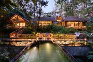 カルペッタにあるEarthitects Holiday Experiences,Wayanadの池のある丸太家