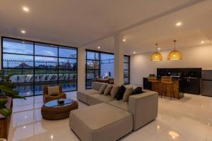 ein großes Wohnzimmer mit Couch und Küche in der Unterkunft 2BR Pool Villa Alba in Canggu, Rice field view in Dalung