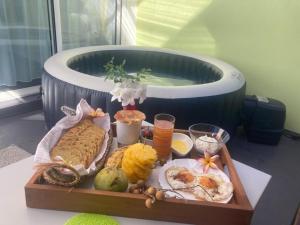 a tray of food on a table next to a bath tub at Un jour ailleurs in Saint-Pierre