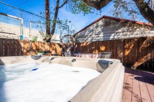 una bañera de hidromasaje en un patio trasero con una valla en New! Spanish Gem-HotTub-Pool-Mins to River Walk, en San Antonio